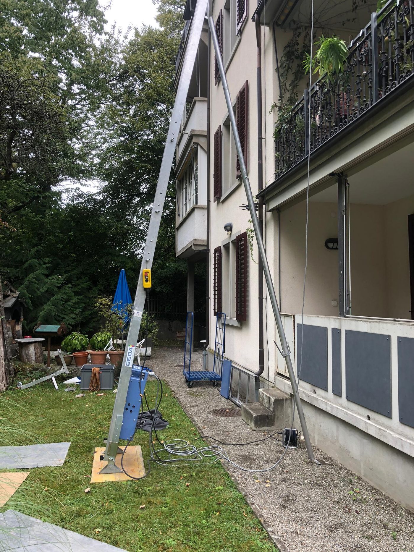 Möbellift, an die Fassade eines Mehrfamilienhauses mit Balkonen gelehnt