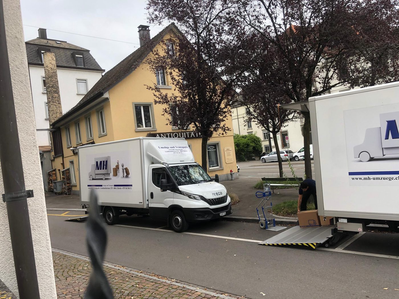 MH-Lastwagen in einer engen Altstadtstrasse, am Rand ein zweiter Wagen