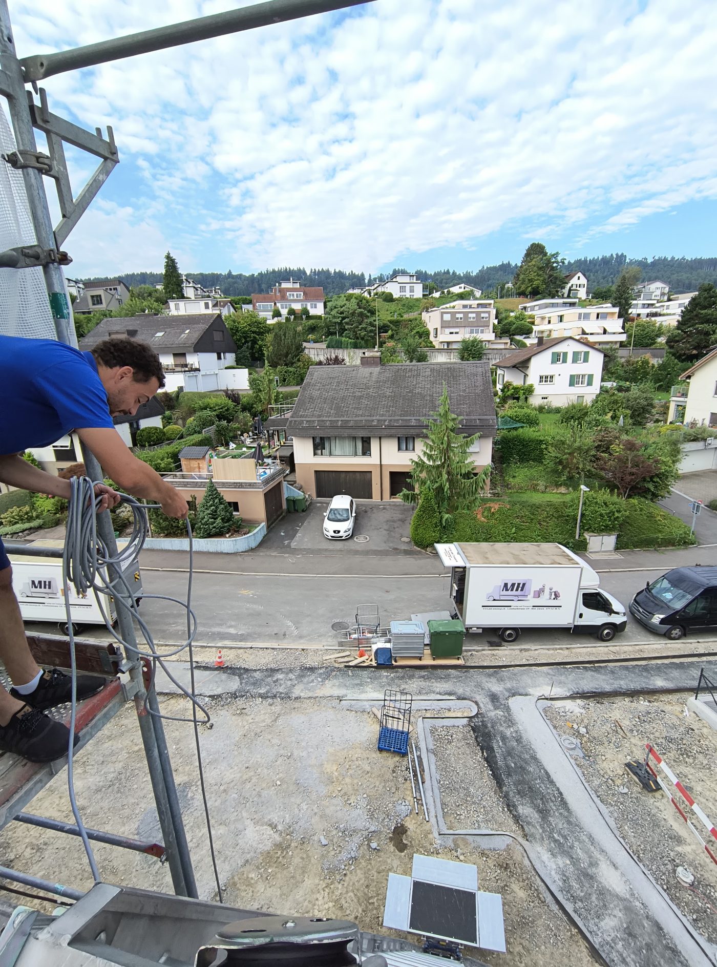 Mitarbeiter am Möbellift mit Blick über die Dächer, unten der Umzugswagen